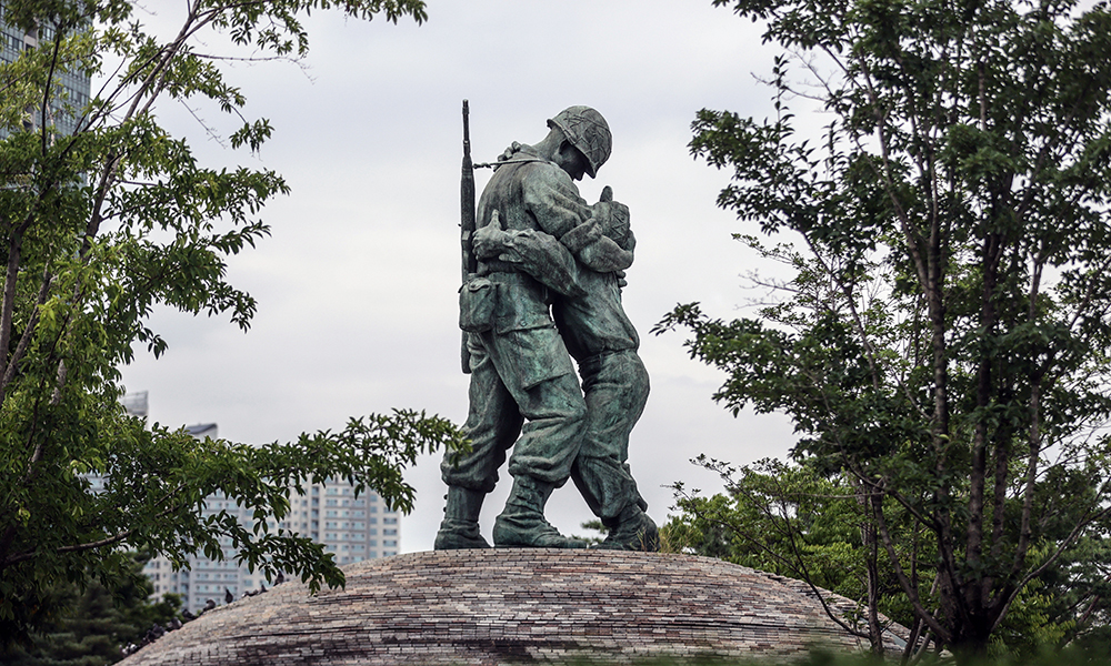 A statue showing a large soldier embracing a smaller one