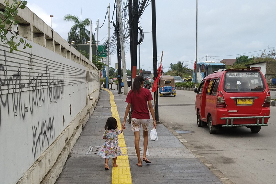 A woman and a child walking down the street