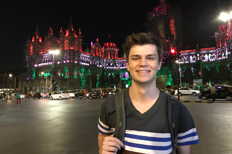 Nick standing outside in front of a lit up historical building