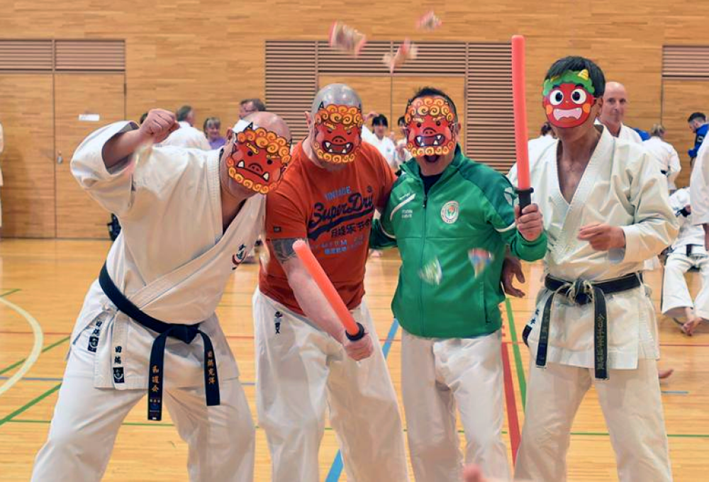 Four of the team in a gym wearing painted demon masks